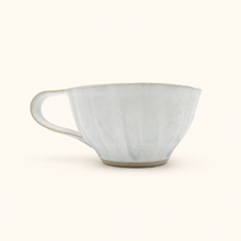 White ceramic teacup on a white background