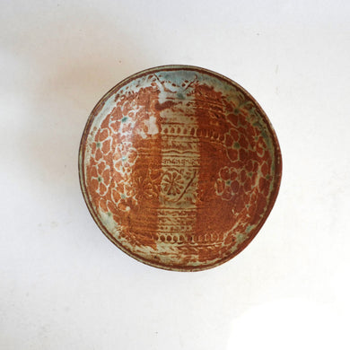 Ceramic bowl with decorative brown and beige pattern on a white background
