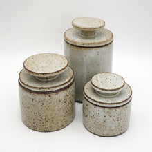 Set of three MH Ceramic Studio ceramic jars with speckled glaze on a white background