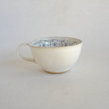 Cappuccino mug with blue flower pattern on beige background