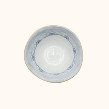 Ceramic bowl with blue decorative rim on a white background