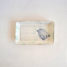 Rectangular ceramic dish with a decorative pattern on a light background