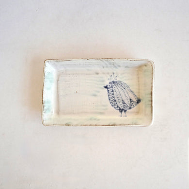 Rectangular ceramic dish with a decorative pattern on a light background