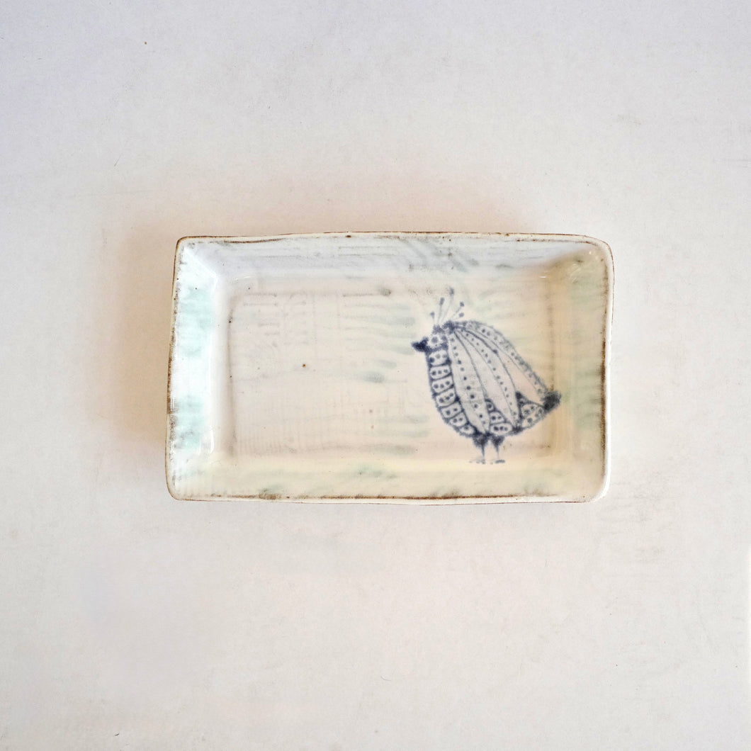 Rectangular ceramic dish with a decorative pattern on a light background
