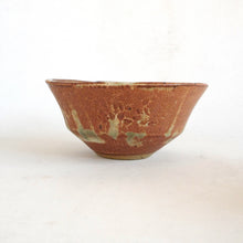 Ceramic bowl with brown and green glaze on a white background