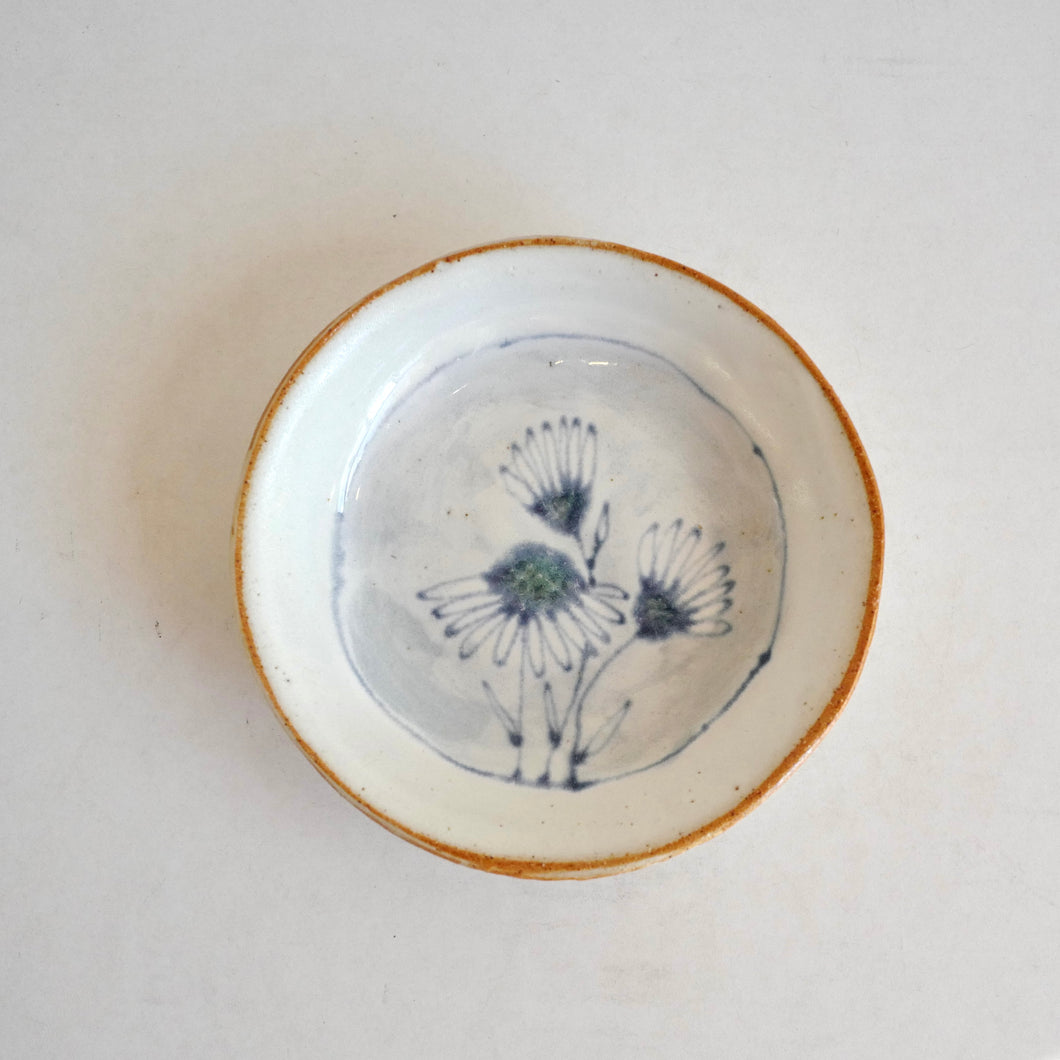 small plate with  blue daisies pattern on white background