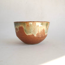 Ceramic bowl with green/white glaze on a white background