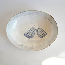 Ceramic plate with blue line art of love birds on a white background