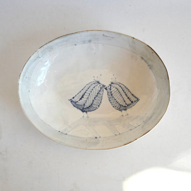 Ceramic plate with blue line art of love birds on a white background