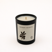Candle in a black container with 'Desert Heights' label on a white background