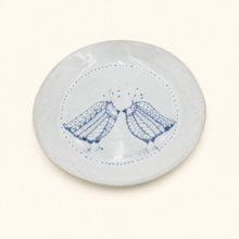 White ceramic plate with blue bird design on a white background