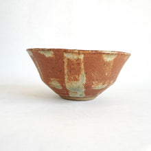 Ceramic bowl with a rustic brown and beige glaze on a white background