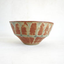 Ceramic bowl with brown and green glaze on a white background