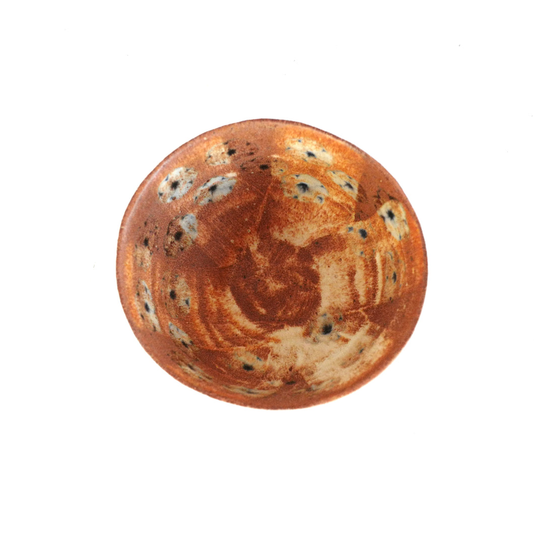 Round ceramic bowl with brown and blue floral pattern on a white background