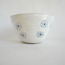White ceramic bowl with blue floral patterns on a white background