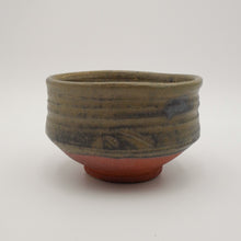 A handmade ceramic tea bowl with a textured, ribbed upper half in earthy olive-brown glaze and a contrasting reddish-brown base, shown on a neutral light gray background.