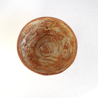 Round ceramic bowl with marbled brown and beige design on a white background