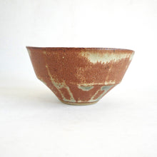 Ceramic bowl with brown and beige glaze on a white background