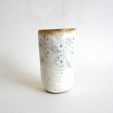 Spako Clay tumbler blue line drawing of flowers and emboss pattern, white glaze