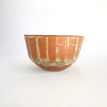 Ceramic bowl with brown and green glaze on a white background