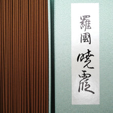 Incense sticks in a box and box cover with black calligraphy on a light blue background