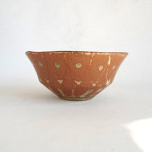 Ceramic bowl with brown and beige speckled pattern on a white background