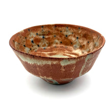 Ceramic bowl with speckled brown and beige design on a white background
