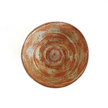 Round ceramic bowl with a natural, swirled pattern on a white background