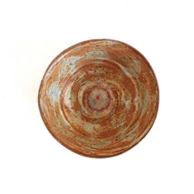 Round ceramic bowl with a natural, swirled pattern on a white background