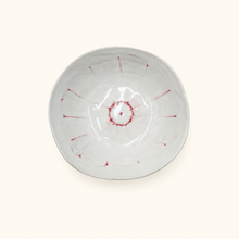 White ceramic bowl with red decorative elements on a white background