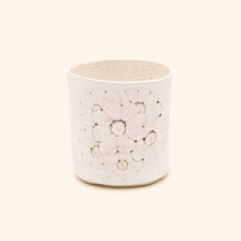 White ceramic vase with floral pattern on a white background