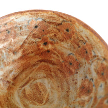 Close-up of a ceramic bowl with brown and beige design on a white background