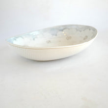 White ceramic bowl with subtle pattern on a light gray background