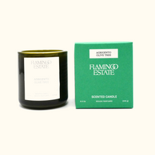 Black candle with white label and green box labeled 'Flamingo Estate' on a white background