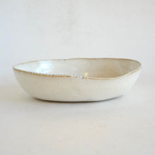 White ceramic bowl with a textured surface on a light gray background