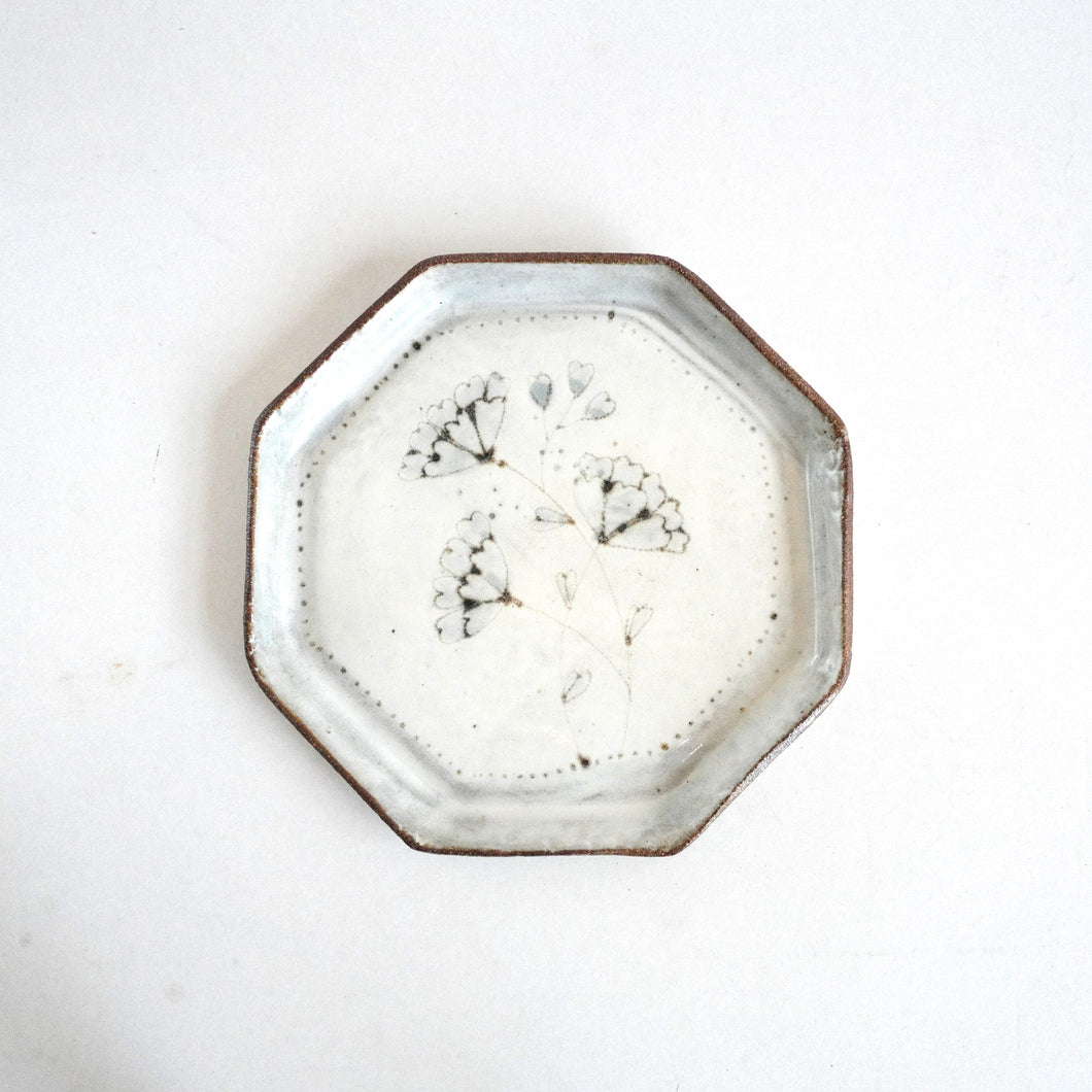 Octagonal ceramic plate with floral design on a white background
