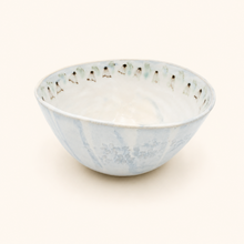 White ceramic bowl with blue floral pattern on a white background
