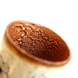 Close-up of cup with intricate patterns on a white background