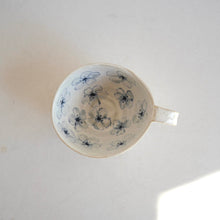 Cappuccino mug with blue flower pattern on beige background