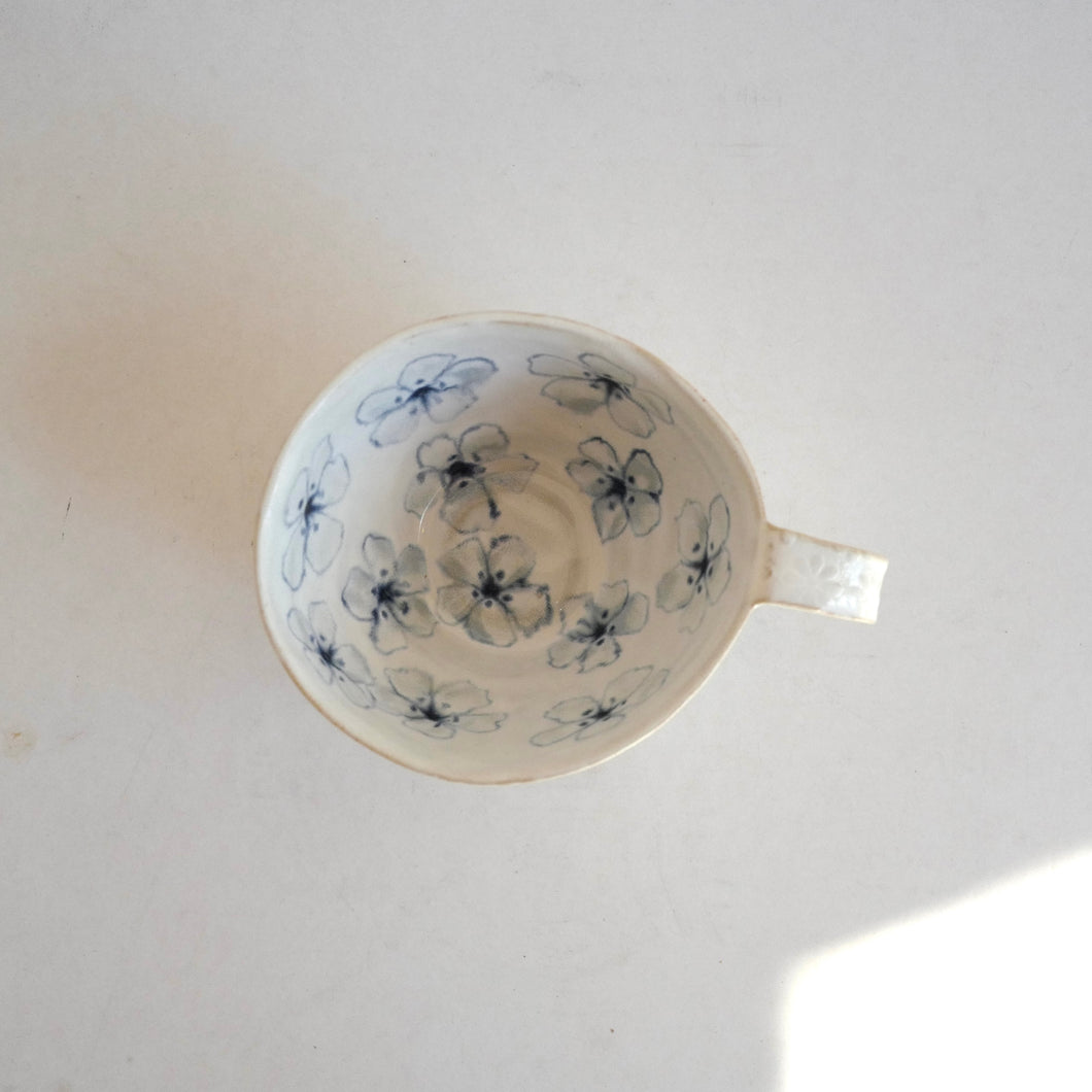 Cappuccino mug with blue flower pattern on beige background