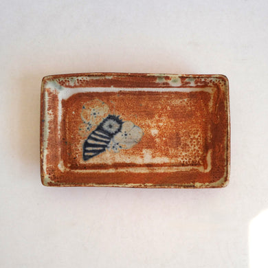 Rectangular ceramic dish with a decorative blue and white design on a light background