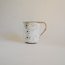 Spako Clay mug, wild flower design with floral texture. Mug handle on right