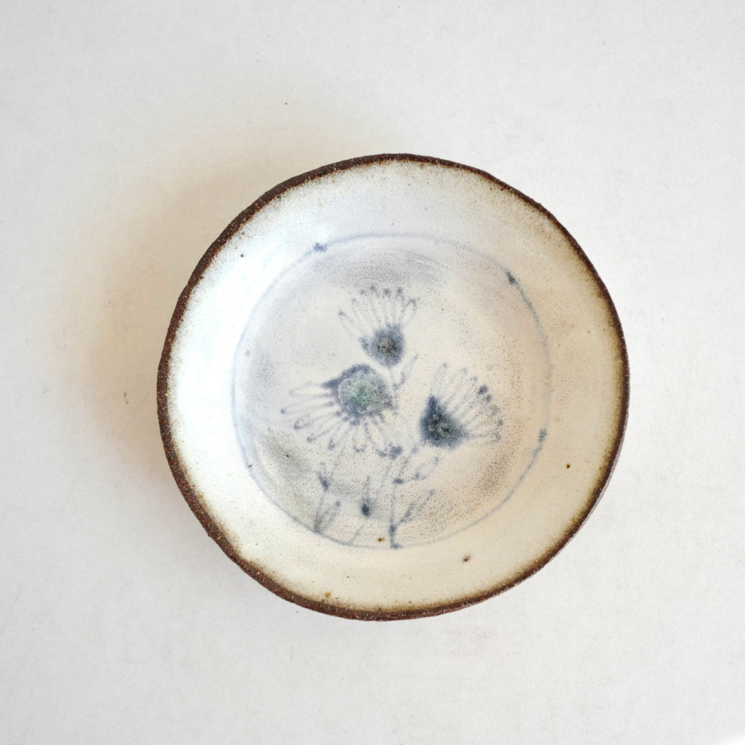 small plate with  blue daisies pattern on white background