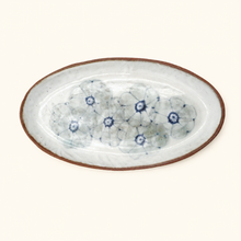 Oval ceramic dish with floral pattern on a white background