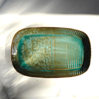 Rectangular ceramic dish with textured surface on a white background
