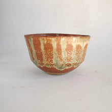 Ceramic bowl with brown and green glaze on a white background
