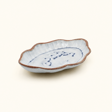 Small ceramic dish with blue patterns on a white background