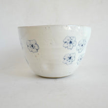 White ceramic bowl with blue floral patterns on a white background
