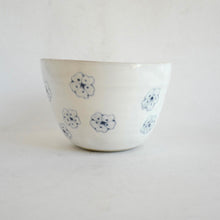 White ceramic bowl with blue floral patterns on a white background