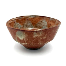 Brown ceramic bowl with speckled pattern on a white background
